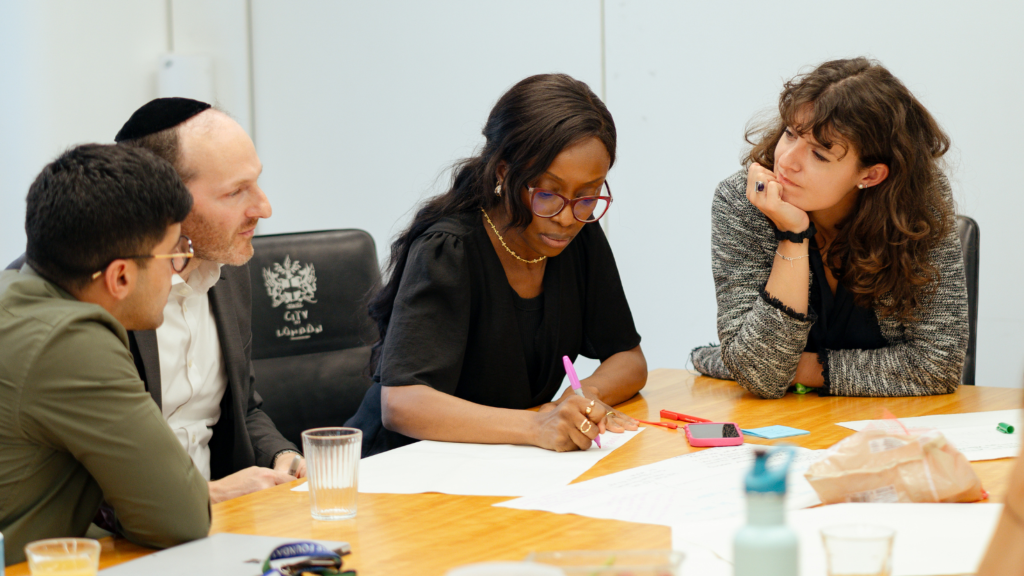 Participants working together around a table at a City Bridge Foundation Anchor Programme workshop.