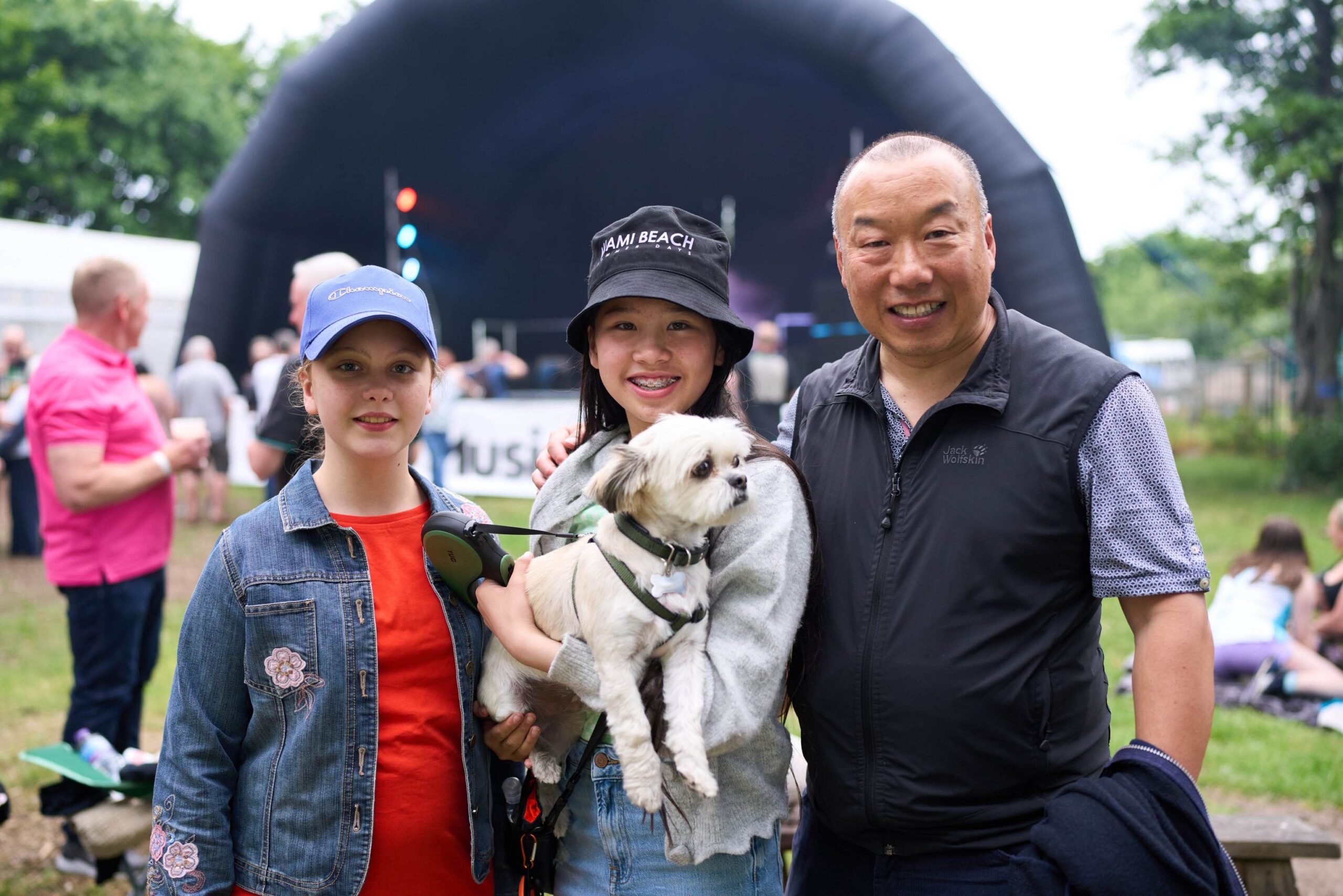 Community members with a dog at an outdoor event.