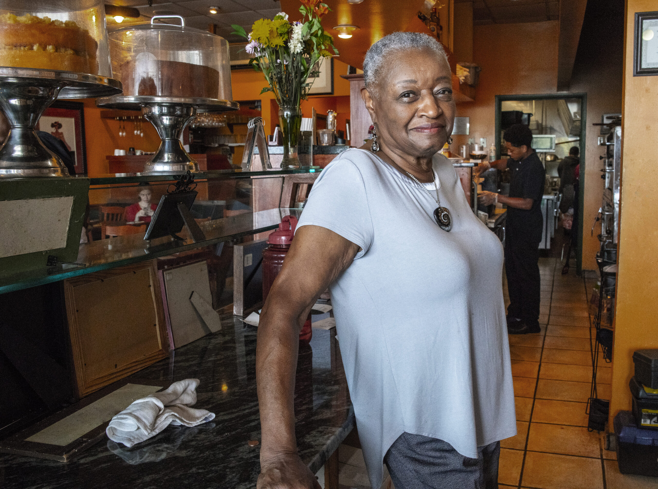 A woman standing inside a cafe.