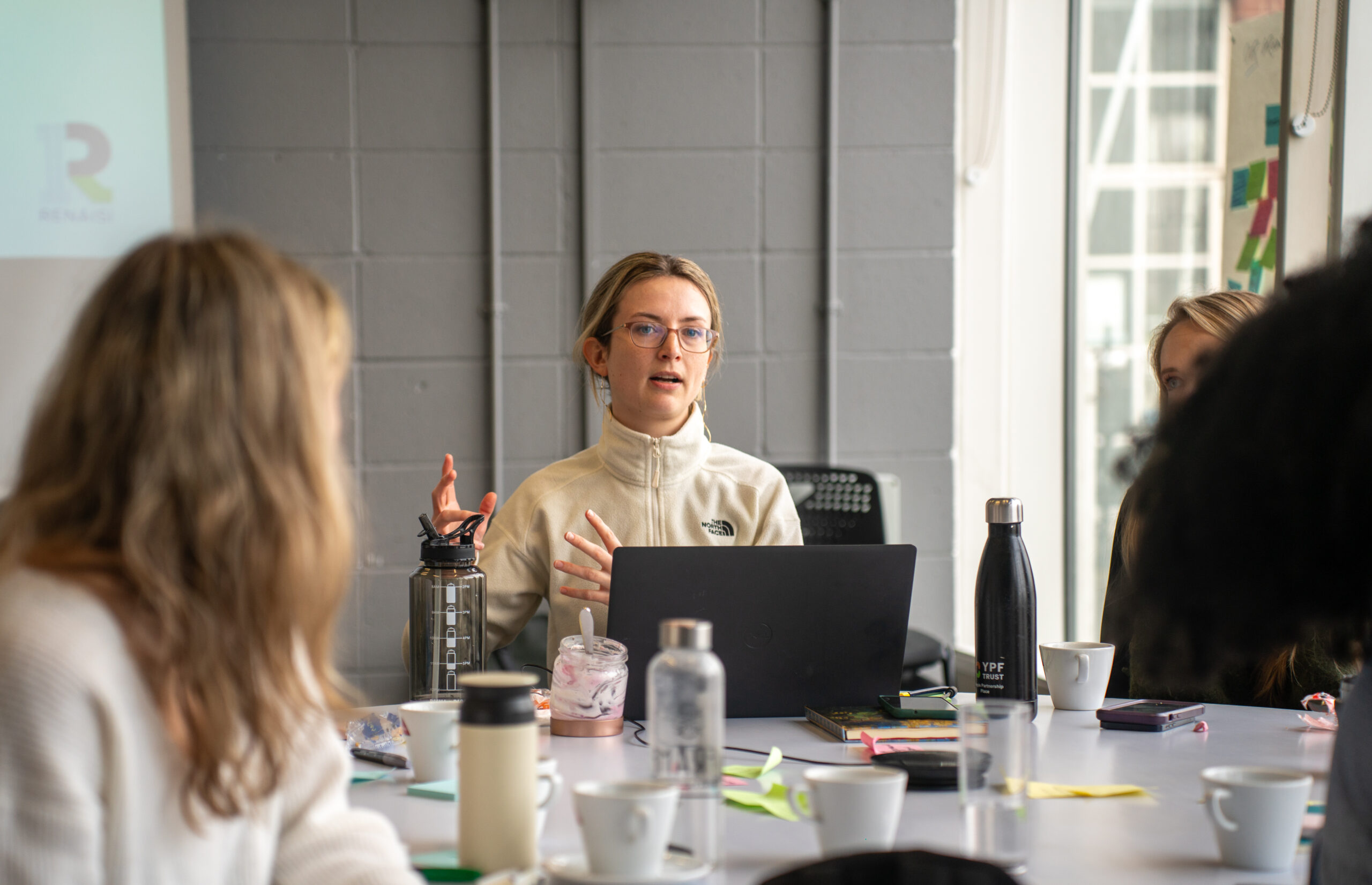 A participant speaking during a workshop around a table.