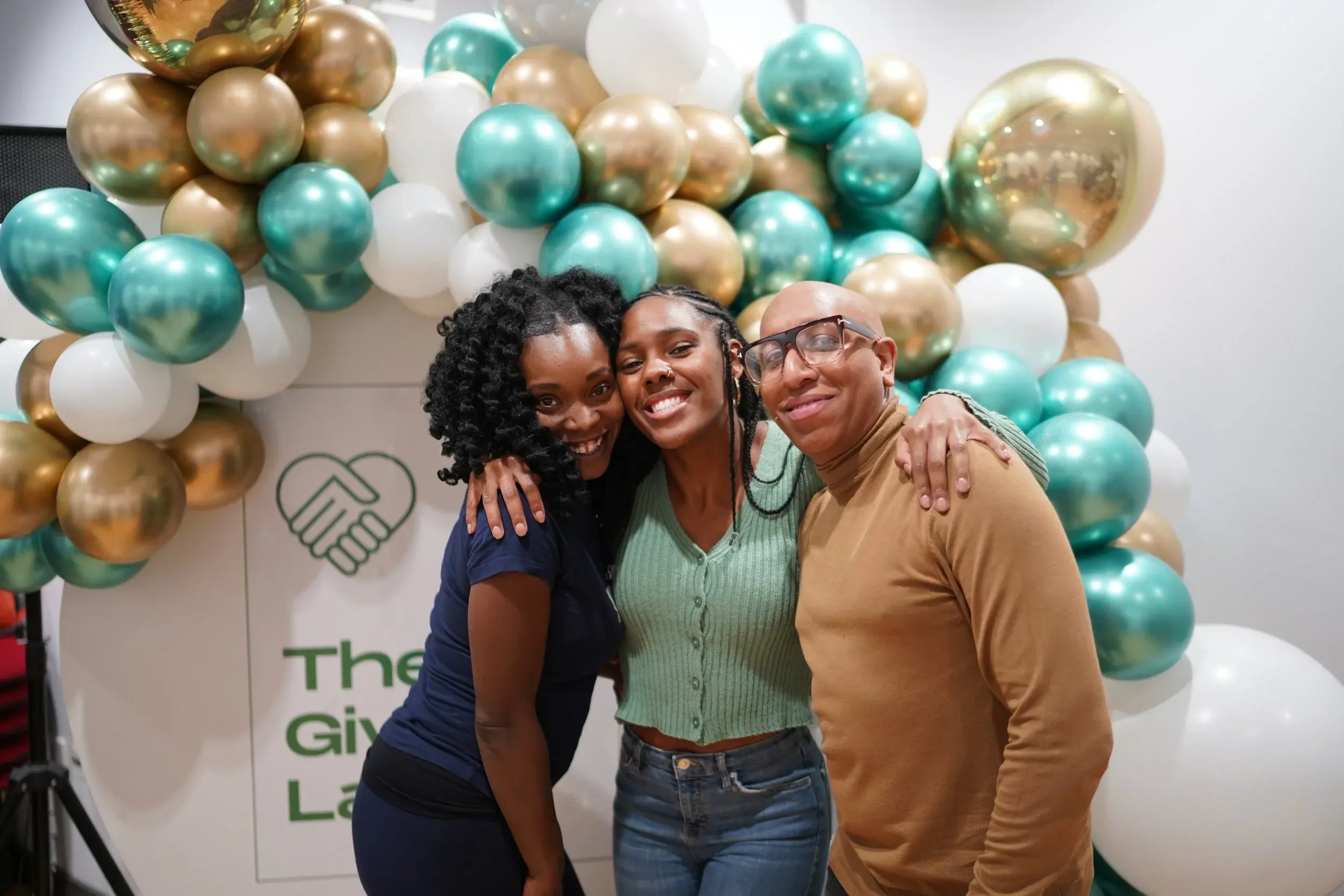 Three guests smiling together at The Giving Lab Winter Gala 2025.
